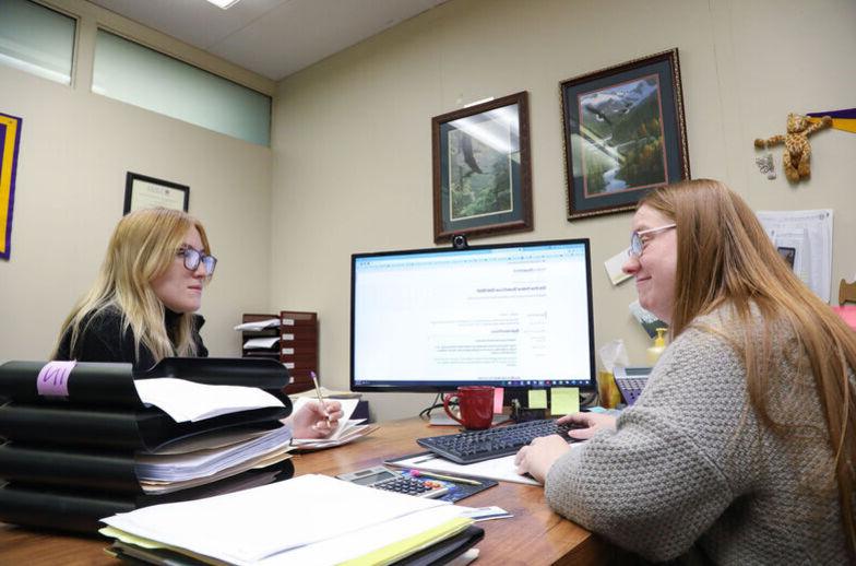 A financial aid employee helps a student in her office